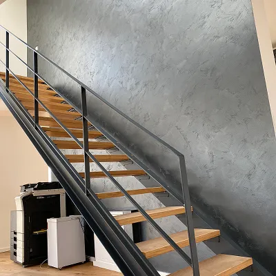 Graue Wand in Spachteltechnik neben einer Stahltreppe